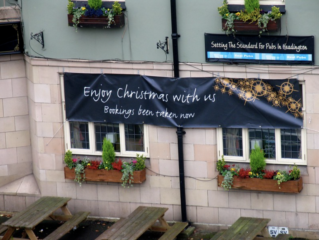 A small cafe with a banner that says Enjoy Christmas with us. Bookings been taken now